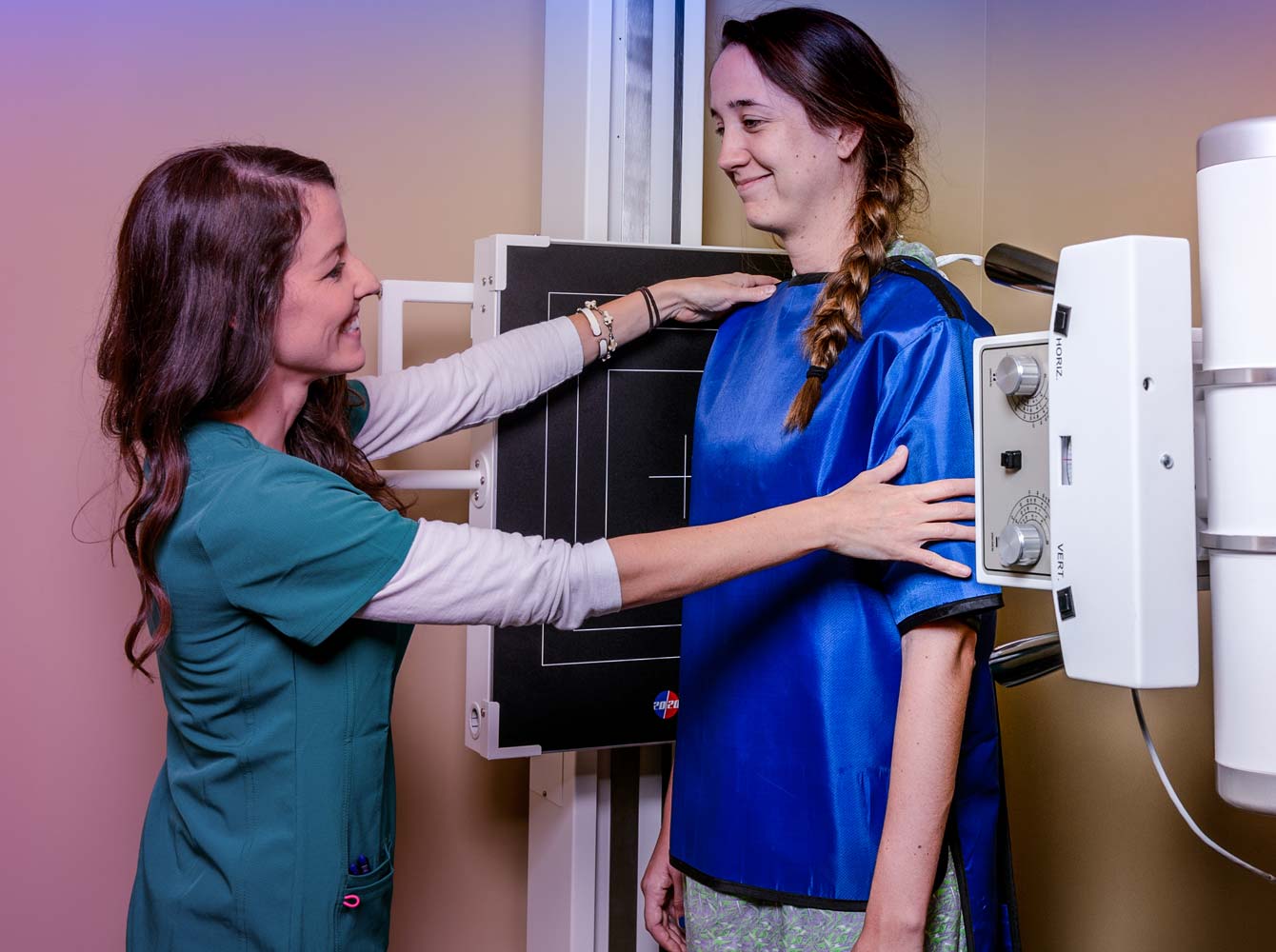 a clinician positioning a client for a spine xray