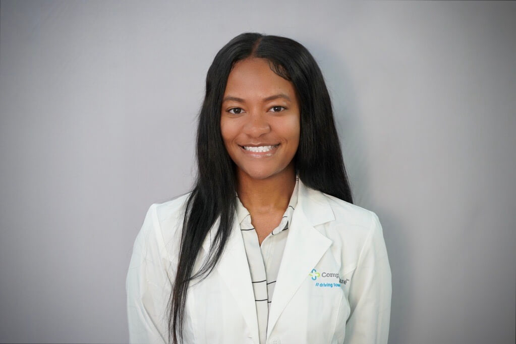 a woman wearing a white lab coat that says community health